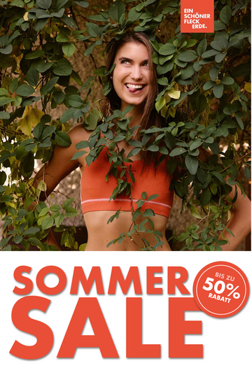 Frau im orangefarbenen Sport-Bustier zwischen grünen Blättern – Sommer Sale Ein schöner Fleck Erde bis zu 50 Prozent Rabatt