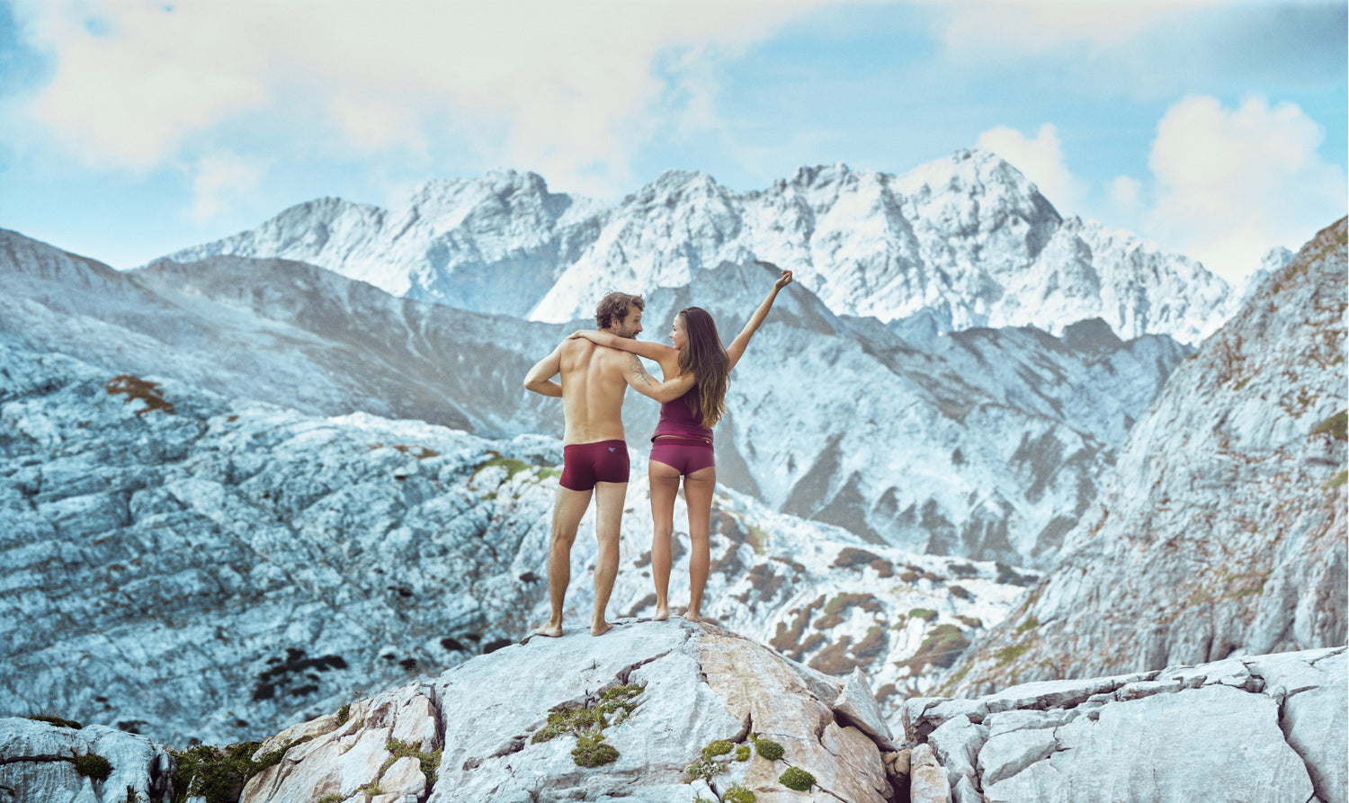 Paar in Merino-Unterwäsche mit Blick auf verschneite Alpen 