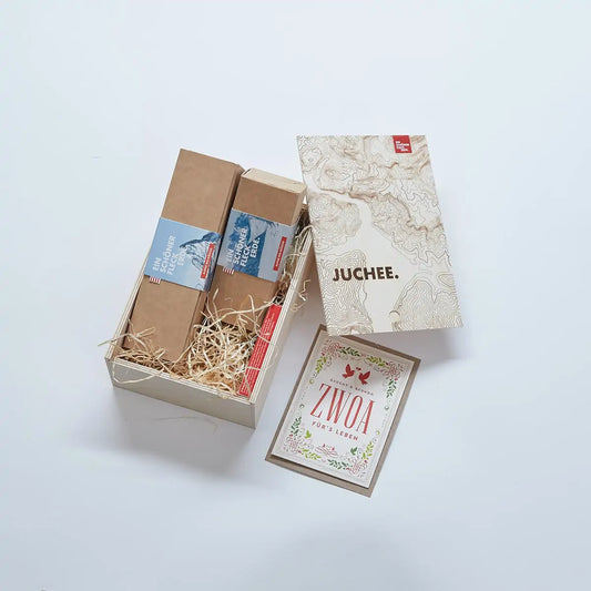 Geschenkbox „JUCHEE.“ von Ein schöner Fleck Erde mit zwei nachhaltig verpackten Unterwäsche-Sets und Grußkarte „ZWOA fürs Leben“ – hochwertige Geschenkidee mit alpinem Design.